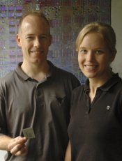 Professor Doug Burger and winner, Franzi Roesner, stand in front of an enlarged photo of the processor they are designing.