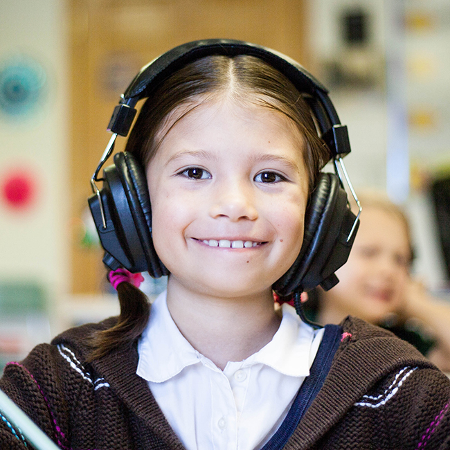 Young child learning with headphones on.